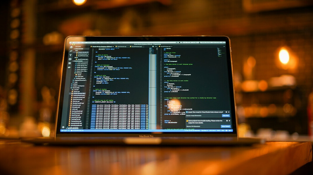 programmer coding on laptop